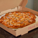 a sausage pizza in a takeout box